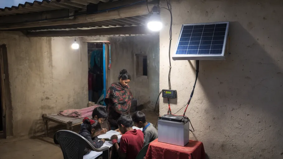 Off-grid solar home system with 12V battery powering LED lighting in rural community