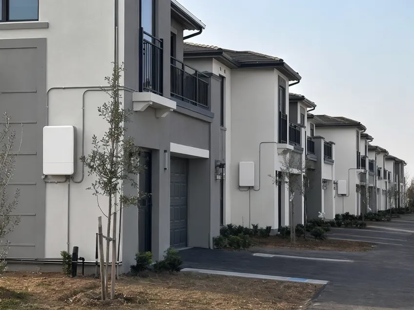 Identical wall mounted batteries installed across multiple homes in a residential development project