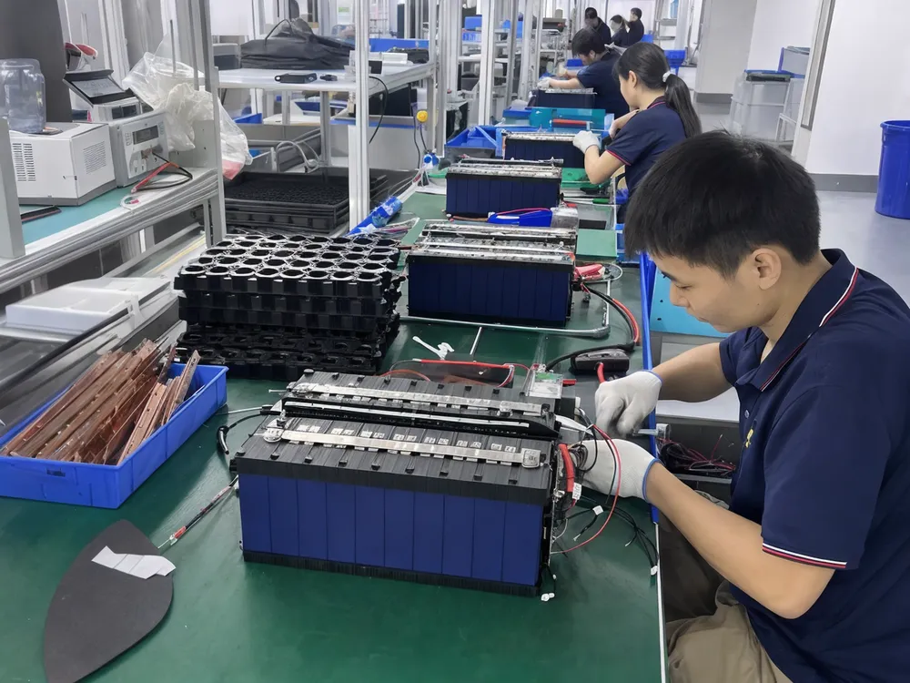 Solar battery energy storage pack assembly — matched LiFePO4 cells being integrated with BMS modules on production line